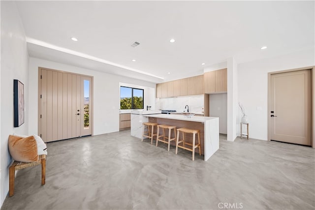 62290 Crestview Dr, Joshua Tree, CA 92252 - kitchen with modern cabinets, a center island, a breakfast bar, light countertops, and concrete floors