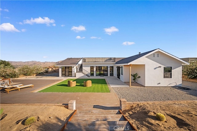 62290 Crestview Dr, Joshua Tree, CA 92252 - back of property with a deck with mountain view, a patio area, and stucco siding