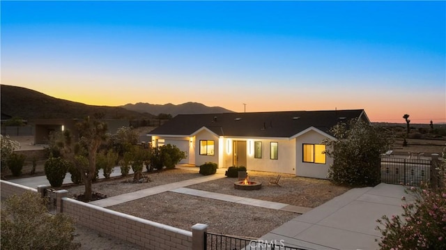 62290 Crestview Dr, Joshua Tree, CA 92252 - view of front of home featuring a fire pit, stucco siding, and a mountain view