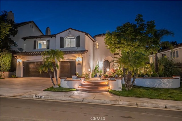 26511 Brooks Cir, Stevenson Ranch, CA 91381 - mediterranean / spanish house with stucco siding, an attached garage, concrete driveway, and a chimney