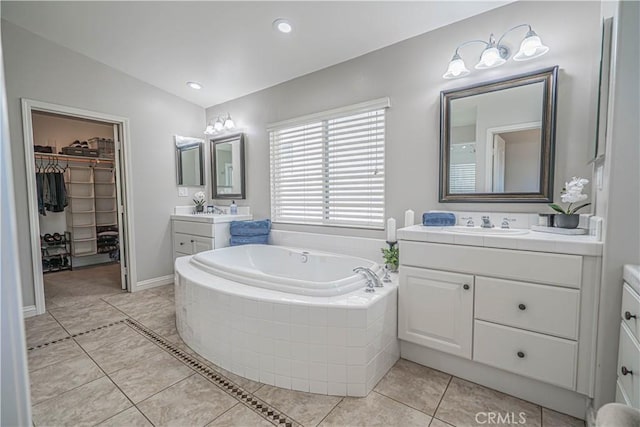 26511 Brooks Cir, Stevenson Ranch, CA 91381 - bathroom featuring two vanities, a garden tub, a spacious closet, tile patterned floors, and recessed lighting