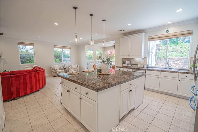 26511 Brooks Cir, Stevenson Ranch, CA 91381 - kitchen with light tile patterned flooring, a kitchen island, ornamental molding, open floor plan, and recessed lighting