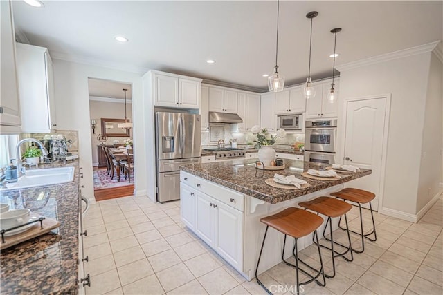 26511 Brooks Cir, Stevenson Ranch, CA 91381 - kitchen with stainless steel appliances, under cabinet range hood, light tile patterned floors, ornamental molding, and backsplash