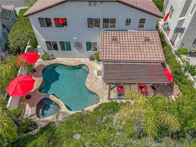 26511 Brooks Cir, Stevenson Ranch, CA 91381 - back of house featuring a tiled roof, a patio area, a pool with connected hot tub, and stucco siding