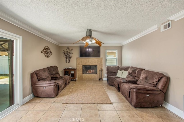 26490 Mapleridge Way, Moreno Valley, CA 92555 - living area featuring crown molding, a ceiling fan, a textured ceiling, light tile patterned flooring, and a tiled fireplace
