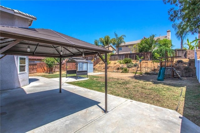 26490 Mapleridge Way, Moreno Valley, CA 92555 - fenced backyard featuring a storage shed, a patio, a gazebo, a playground, and a carport