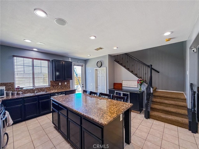 2753 Hornbeam Rd, Palmdale, CA 93551 - kitchen with a kitchen island, light tile patterned floors, stainless steel appliances, tasteful backsplash, and recessed lighting