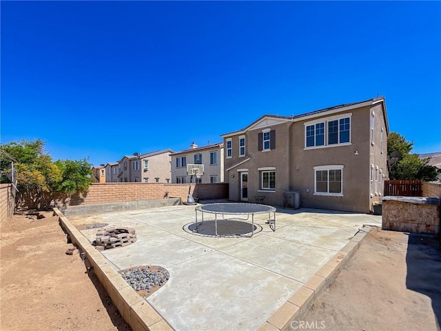 2753 Hornbeam Rd, Palmdale, CA 93551 - rear view of house with a trampoline, a fenced backyard, a patio, and stucco siding