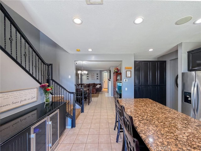 2753 Hornbeam Rd, Palmdale, CA 93551 - kitchen with a chandelier, stainless steel refrigerator with ice dispenser, dark cabinets, light tile patterned flooring, and recessed lighting