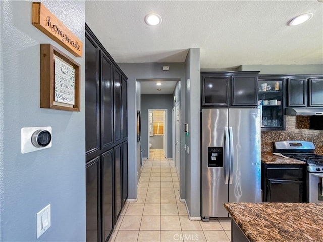 2753 Hornbeam Rd, Palmdale, CA 93551 - kitchen with stainless steel appliances, under cabinet range hood, dark cabinets, light tile patterned floors, and glass insert cabinets