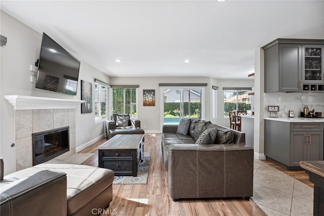 11533 Poppyglen Ct, Moorpark, CA 93021 - living room with plenty of natural light, light wood-style flooring, a tiled fireplace, and recessed lighting