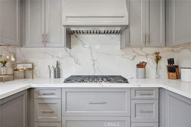11533 Poppyglen Ct, Moorpark, CA 93021 - kitchen featuring gray cabinets, stainless steel gas stovetop, custom range hood, backsplash, and light stone counters