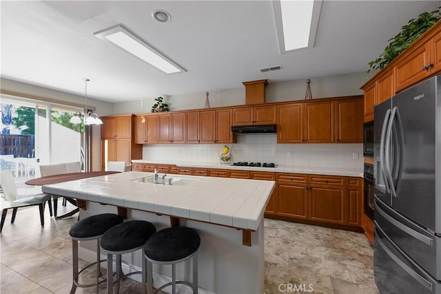 2175 Lester Ave, Clovis, CA 93619 - kitchen with black appliances, under cabinet range hood, and brown cabinetry