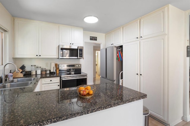17119 W Bernardo Dr Unit 105, San Diego, CA 92127 - kitchen featuring appliances with stainless steel finishes, a peninsula, cream cabinetry, and dark stone counters