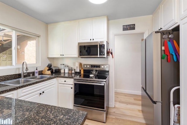 17119 W Bernardo Dr Unit 105, San Diego, CA 92127 - kitchen with stainless steel appliances, light wood finished floors, white cabinetry, and dark stone counters