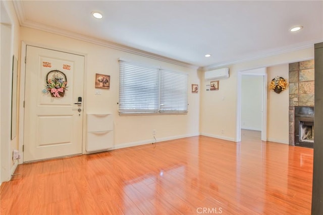 12818 Ramsey Dr, La Mirada, CA 90638 - foyer with a wall unit AC, crown molding, light wood-style flooring, a tile fireplace, and recessed lighting