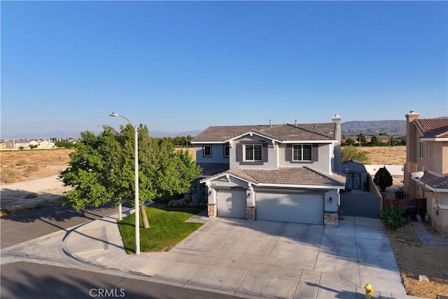 4604 Trojan Ct, Lancaster, CA 93536 - view of front of home featuring an attached garage, stucco siding, stone siding, concrete driveway, and a gate
