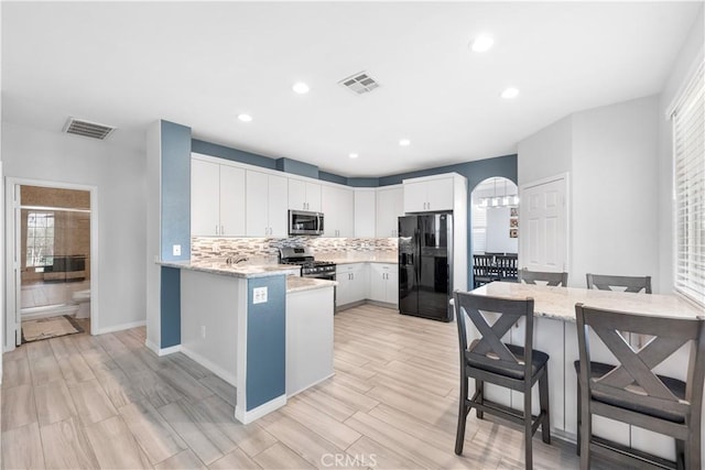 4604 Trojan Ct, Lancaster, CA 93536 - kitchen featuring appliances with stainless steel finishes, backsplash, light wood finished floors, light stone countertops, and recessed lighting