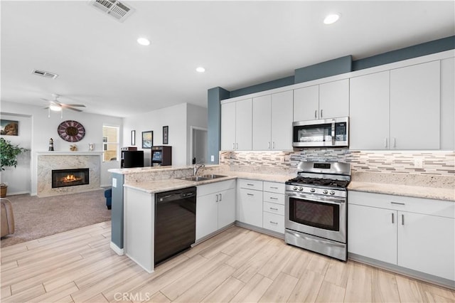 4604 Trojan Ct, Lancaster, CA 93536 - kitchen featuring stainless steel appliances, open floor plan, decorative backsplash, a peninsula, and recessed lighting