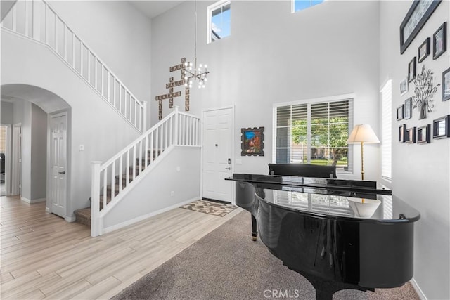 4604 Trojan Ct, Lancaster, CA 93536 - entrance foyer featuring a towering ceiling, arched walkways, stairs, healthy amount of natural light, and wood finished floors