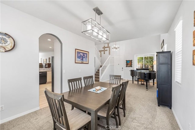 4604 Trojan Ct, Lancaster, CA 93536 - dining space featuring light carpet, arched walkways, stairs, a chandelier, and recessed lighting