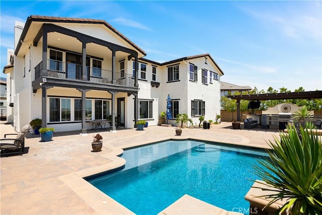 5156 Branding Iron Pl, Rancho Cucamonga, CA 91739 - back of property with a balcony, a patio, stucco siding, an outdoor kitchen, and an outdoor pool