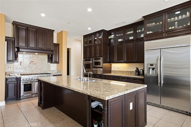 5156 Branding Iron Pl, Rancho Cucamonga, CA 91739 - kitchen with stainless steel appliances, light tile patterned flooring, backsplash, dark brown cabinetry, and recessed lighting