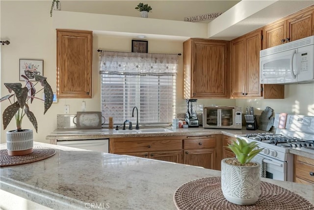 12528 Sonora Way, Victorville, CA 92392 - kitchen featuring white appliances, brown cabinets, and light stone countertops