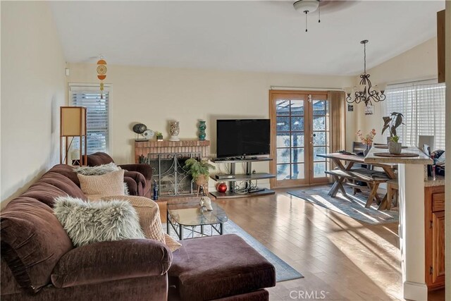 12528 Sonora Way, Victorville, CA 92392 - living area featuring lofted ceiling, wood finished floors, a chandelier, and a brick fireplace