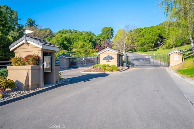247 Oakwood Ct, Arroyo Grande, CA 93420 - view of asphalt road with a gate, curbs, and a gated entry