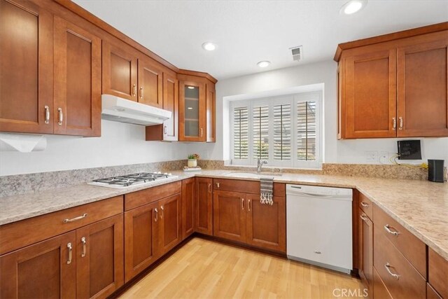 247 Oakwood Ct, Arroyo Grande, CA 93420 - kitchen with white appliances, brown cabinets, under cabinet range hood, light wood-style floors, and recessed lighting