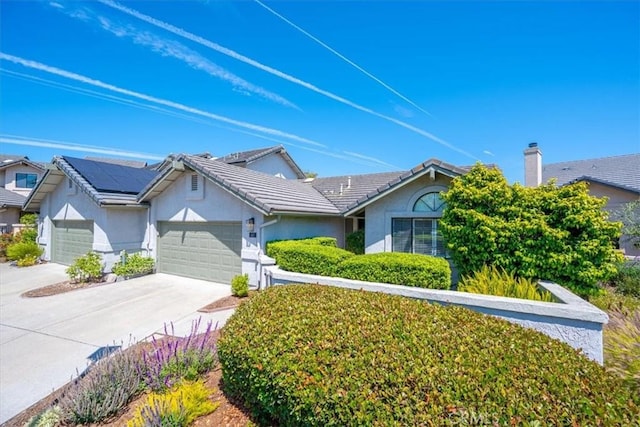 247 Oakwood Ct, Arroyo Grande, CA 93420 - view of front of property featuring stucco siding, an attached garage, driveway, and roof mounted solar panels