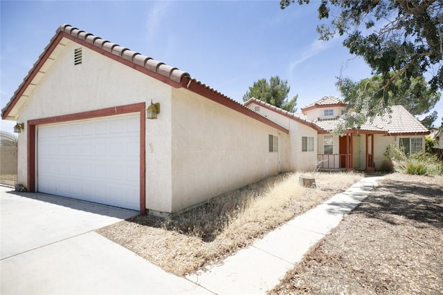 44105 Acacia St, Lancaster, CA 93535 - view of property exterior with a tile roof, stucco siding, an attached garage, and driveway