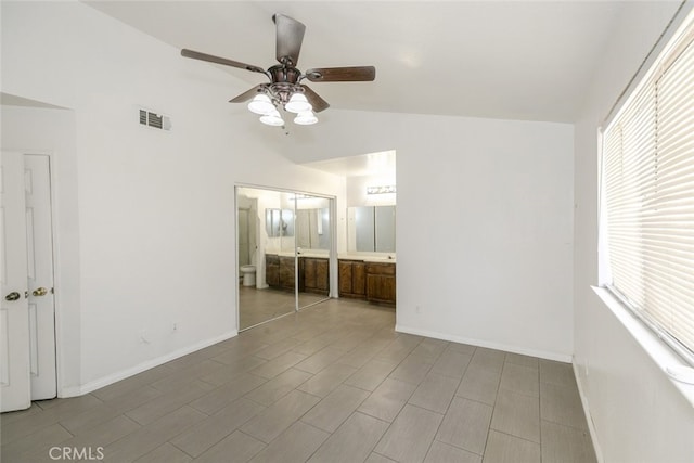 44105 Acacia St, Lancaster, CA 93535 - unfurnished bedroom featuring multiple windows, ensuite bathroom, vaulted ceiling, and ceiling fan