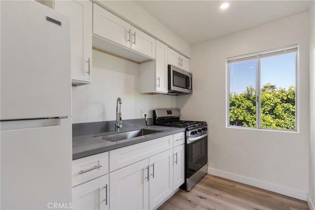 475 E Foothill Blvd, Pomona, CA 91767 - kitchen with stainless steel appliances, dark countertops, light wood-type flooring, white cabinetry, and recessed lighting