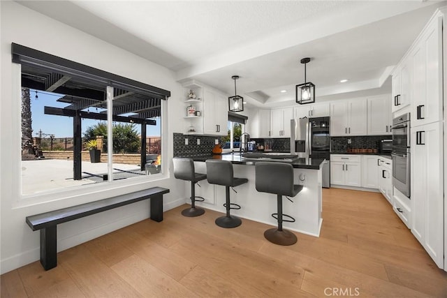 1041 S Falling Leaf Cir, Anaheim Hills, CA 92807 - kitchen featuring stainless steel appliances, dark countertops, a peninsula, a raised ceiling, and backsplash