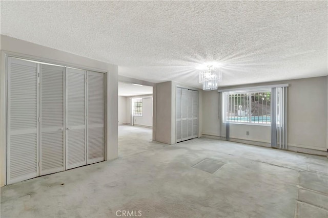 1510 E Newcrest Dr, West Covina, CA 91792 - unfurnished living room featuring plenty of natural light, a chandelier, a textured ceiling, and carpet floors