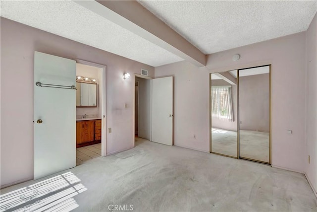 1510 E Newcrest Dr, West Covina, CA 91792 - unfurnished bedroom with a textured ceiling, light carpet, ensuite bath, and a closet