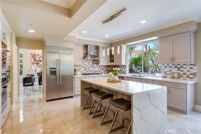 2155 Chandler Dr, Tustin, CA 92782 - kitchen with stainless steel appliances, wall chimney exhaust hood, backsplash, a kitchen bar, and decorative light fixtures