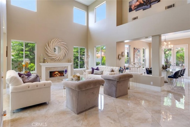 2155 Chandler Dr, Tustin, CA 92782 - living area with light marble finish flooring, healthy amount of natural light, a high end fireplace, a towering ceiling, and a chandelier