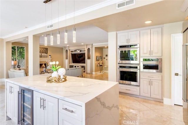 2155 Chandler Dr, Tustin, CA 92782 - kitchen featuring wine cooler, stainless steel double oven, light stone counters, a center island, and recessed lighting