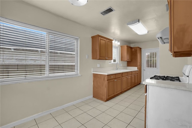 112 E Central Ave, San Gabriel, CA 91776 - kitchen featuring extractor fan, light countertops, light tile patterned flooring, and brown cabinetry