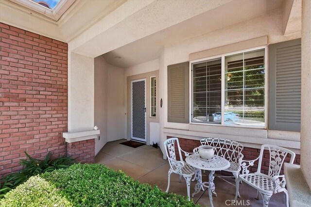 875 Eastlake Rd, Beaumont, CA 92223 - doorway to property with a porch, brick siding, and stucco siding
