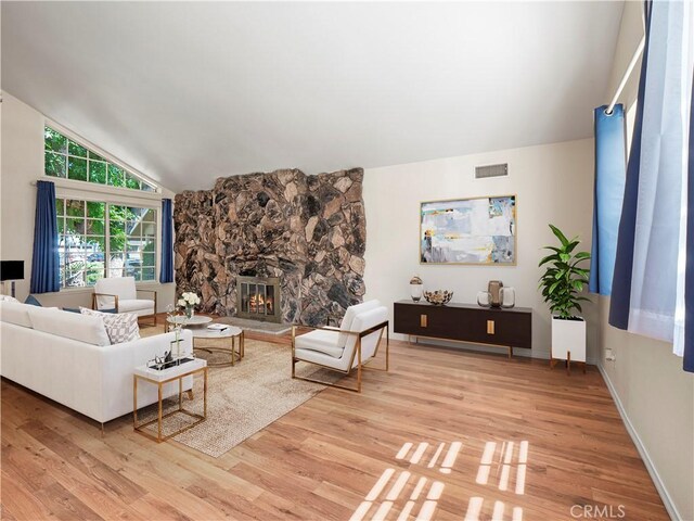 22905 Las Mananitas Dr, Valencia, CA 91354 - living room featuring vaulted ceiling, light wood finished floors, and a fireplace