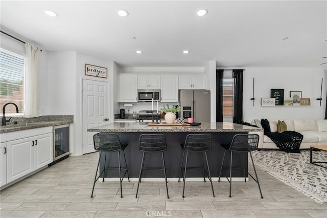 4360 Rima Dr, Fontana, CA 92336 - kitchen featuring appliances with stainless steel finishes, beverage cooler, recessed lighting, healthy amount of natural light, and white cabinetry