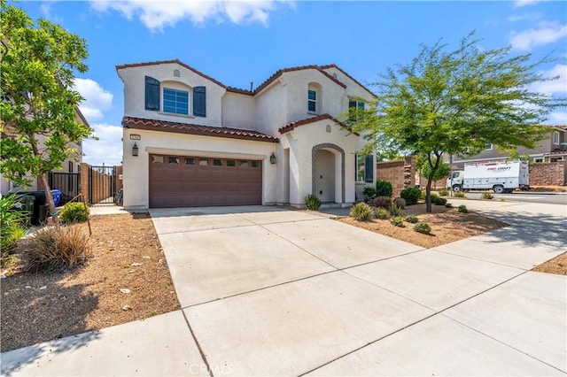 4360 Rima Dr, Fontana, CA 92336 - mediterranean / spanish-style house with stucco siding, driveway, a tile roof, an attached garage, and a gate