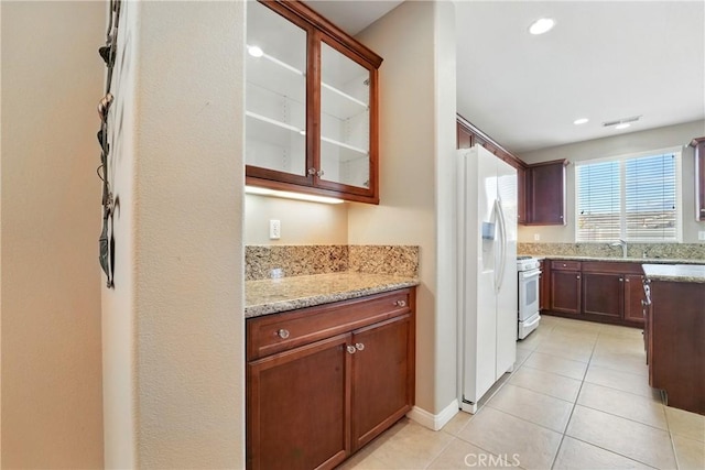 1544 Big Bnd, Beaumont, CA 92223 - kitchen with white appliances, light tile patterned flooring, glass insert cabinets, and light stone countertops