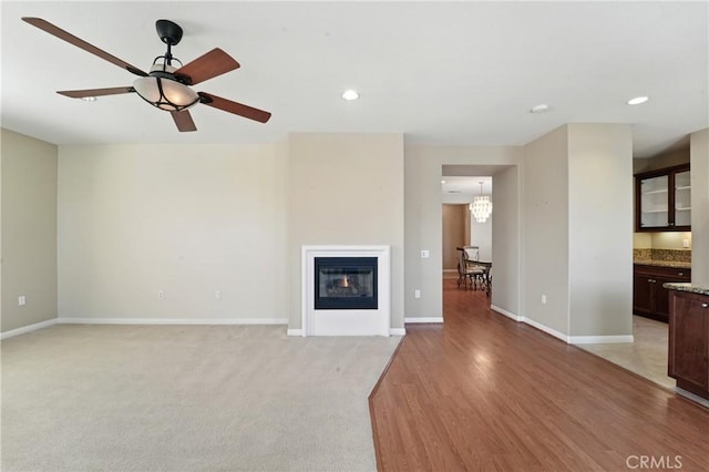 1544 Big Bnd, Beaumont, CA 92223 - unfurnished living room featuring recessed lighting, a ceiling fan, a glass covered fireplace, light wood-style floors, and a chandelier
