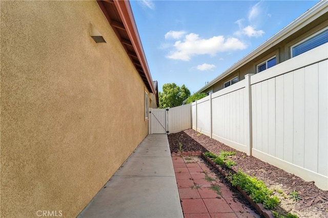 1544 Big Bnd, Beaumont, CA 92223 - view of side of property with stucco siding, a gate, and a patio