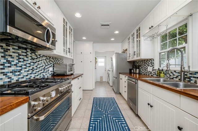 4115 E 10th St, Long Beach, CA 90804 - kitchen with wooden counters, stainless steel appliances, backsplash, white cabinets, and recessed lighting